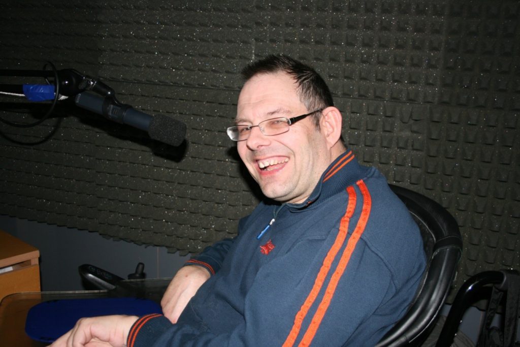 Frankie, sitting in front of a microphone narrating