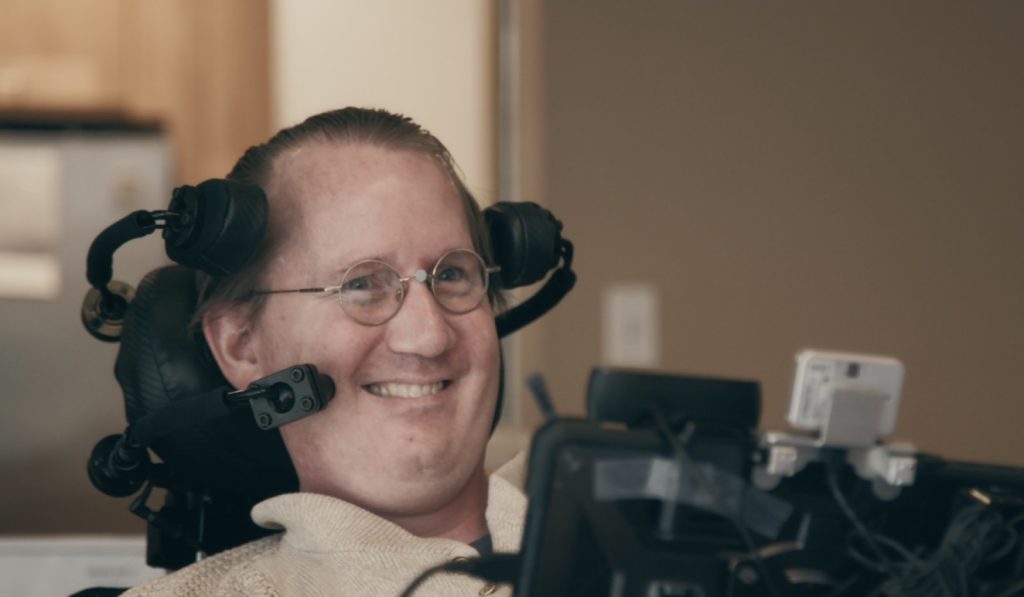 Man in wheelchair using assistive technology 