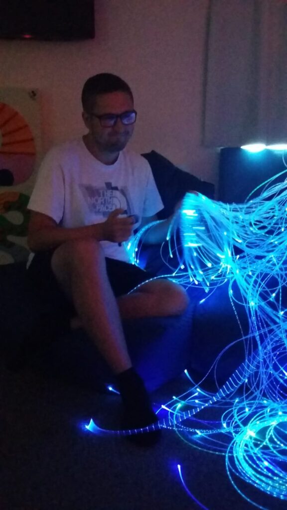 Person sitting holding the interactive fibreoptic unit  
