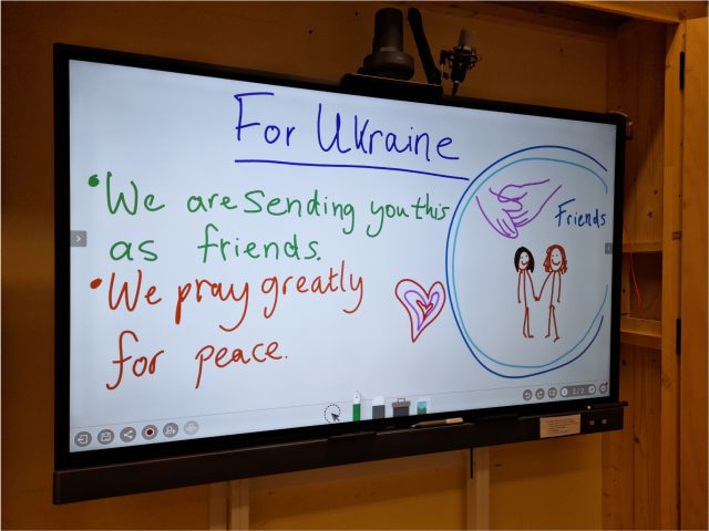 An iBoard showing a hand wrtten message for people in the Ukraine