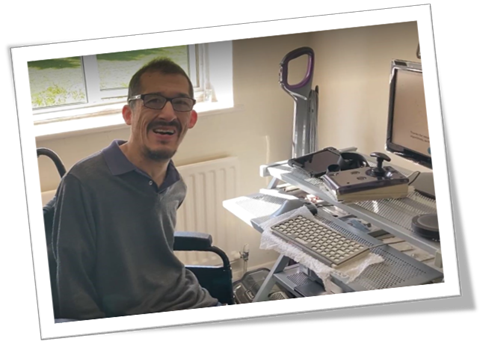 Haroon Sahir sitting in his wheelchair in front of his computer