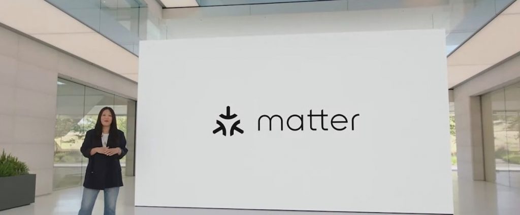 Lady standing next to a screen showing the Matter logo talking about the new apple home app