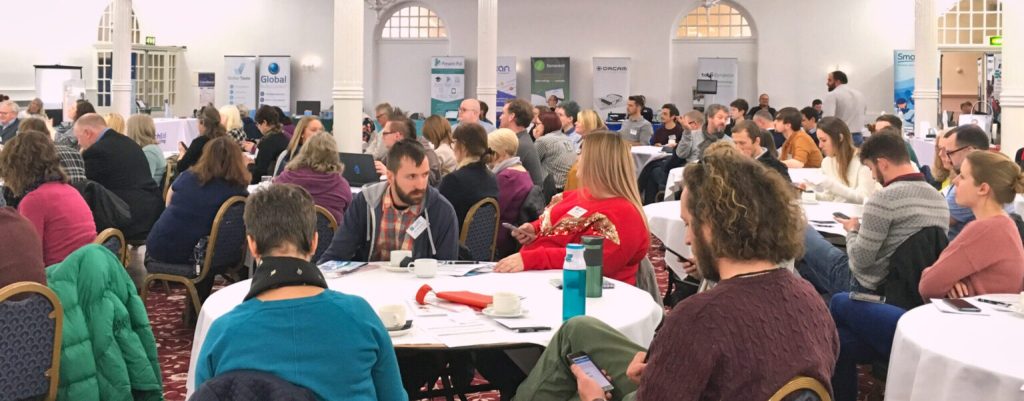 Groups of people sitting round tables at a conference