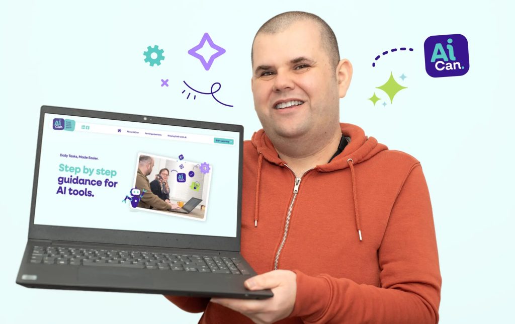 Matt Leadbeater, a smiling man wearing an orange zip-up hoodie, holds a laptop open to the AI CAN website, which displays the text "Step by step guidance for AI tools.